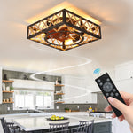 Low profile flush mount industrial style square ceiling fan light fixture installed over a farmhouse dining room table.