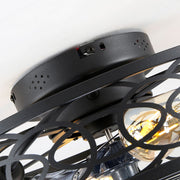 Close up view of the top matte black metal mounting canopy of a ceiling fan showing pre-drilled holes and the upper edge of the geometric iron cage frame