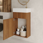 Interior storage space of a plywood bathroom vanity showing an adjustable flexible gray drain pipe.